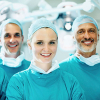 Three surgeons wearing scrubs and smiling at camera