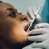 Woman having dental examination with mirror and probe