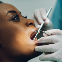Woman having dental examination with mirror and probe